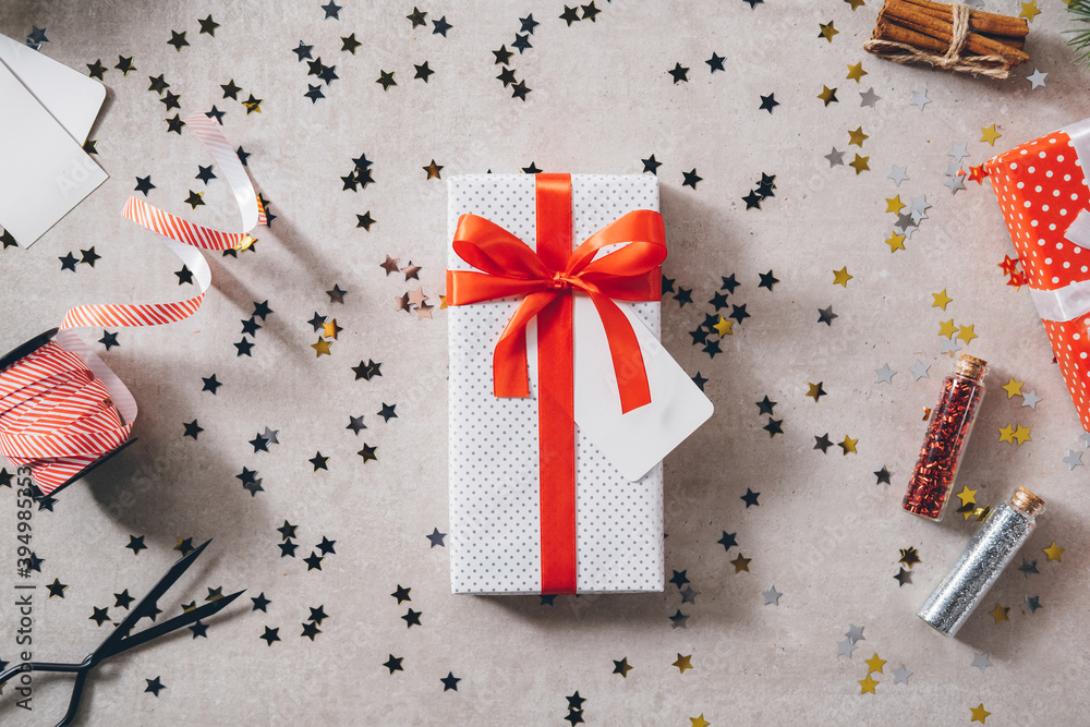 White present with red ribbon bow on decorated festive table