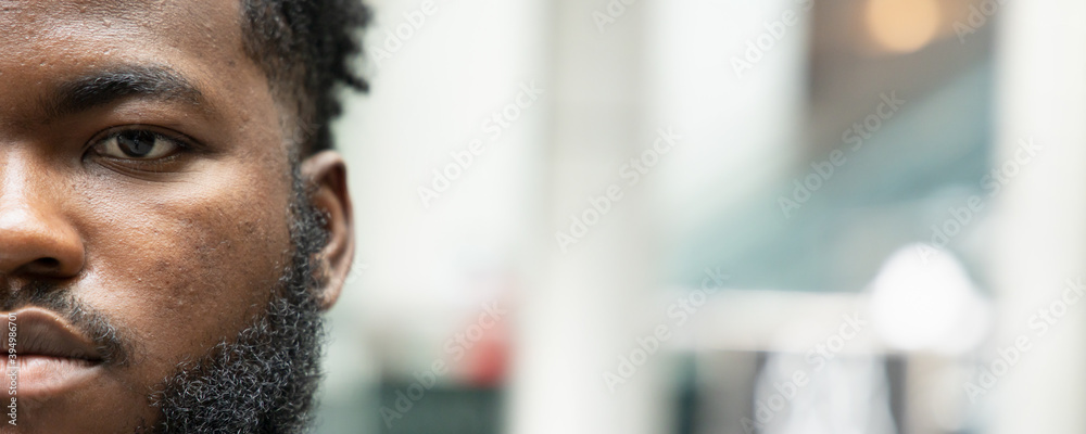 Banner of half face portrait of confident black African man looking at you Banner of half face portrait of confident black African man looking at you