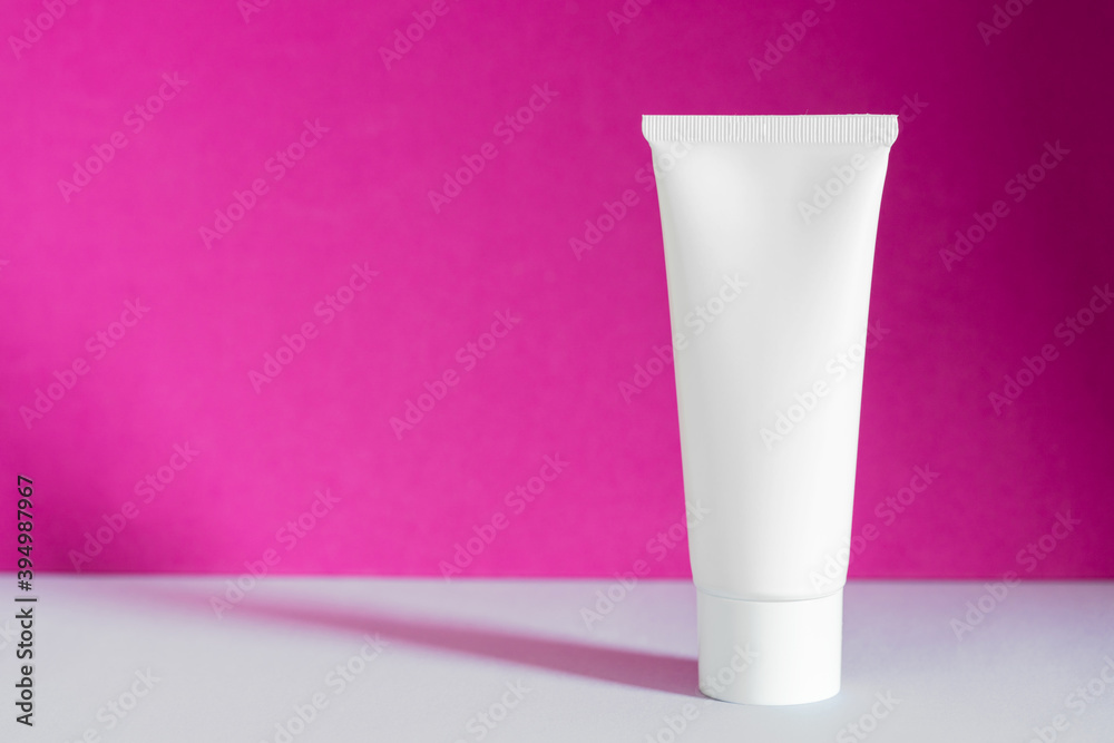 White cream tube blank bottle packaging on purple background. Beauty product mockup package, advertising brand, natural cosmetic, serum, skincare. Skin care moisturizing cosmetic template. Copy space White cream tube blank bottle packaging on purple background. Beauty product mockup package, advertising brand, natural cosmetic, serum, skincare. Skin care moisturizing cosmetic template. Copy space
