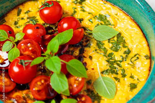 Baked egg omelet with tomatoes and basil in blue dish. Breakfast concept. photo