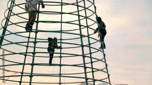 High-altitude installers assembling the frame of the Christmas tree