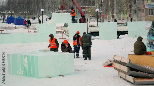 Workers build an ice town from ice blocks for the Christmas holidays