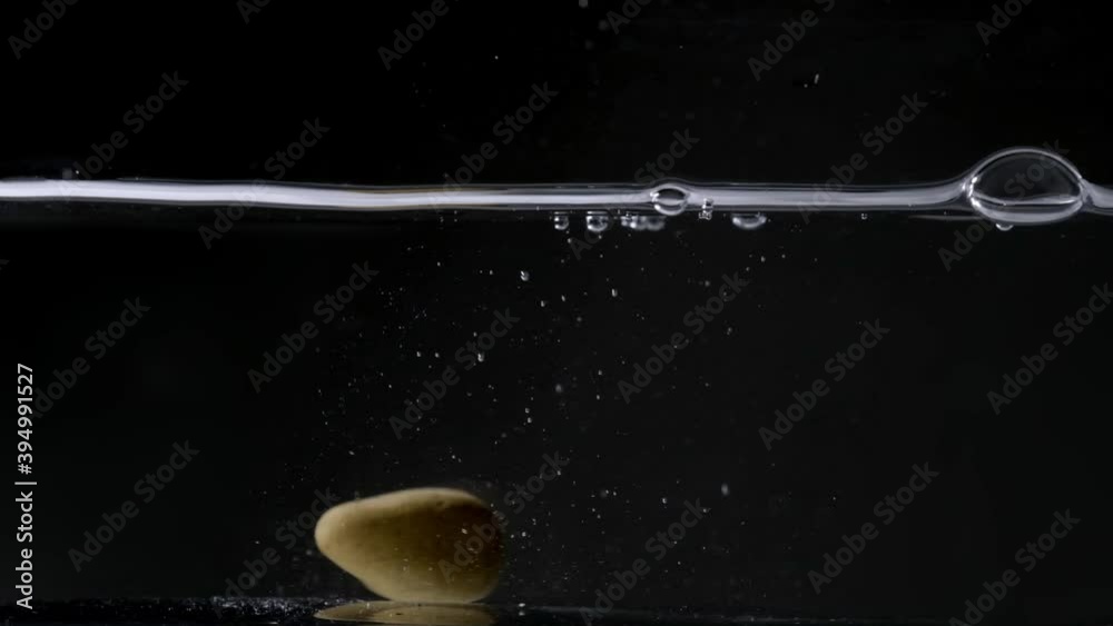 stone falling into the water. Dark background stone falling into the water. Dark background