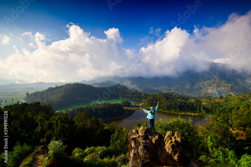 Woman posing on Batu Pandang Ratapan Angin Telaga Warna / Warna Lake Dieng plateau wonosobo central java indonesia.
