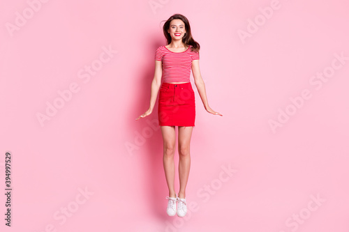 Full size photo of young beautiful smiling cheerful charming girl with red lipstick jump fly isolated on pink color background