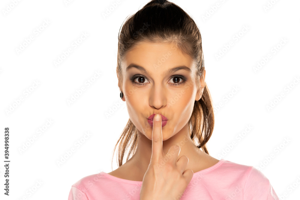 portrait of a young beautiful woman kissing her finger portrait of a young beautiful woman kissing her finger