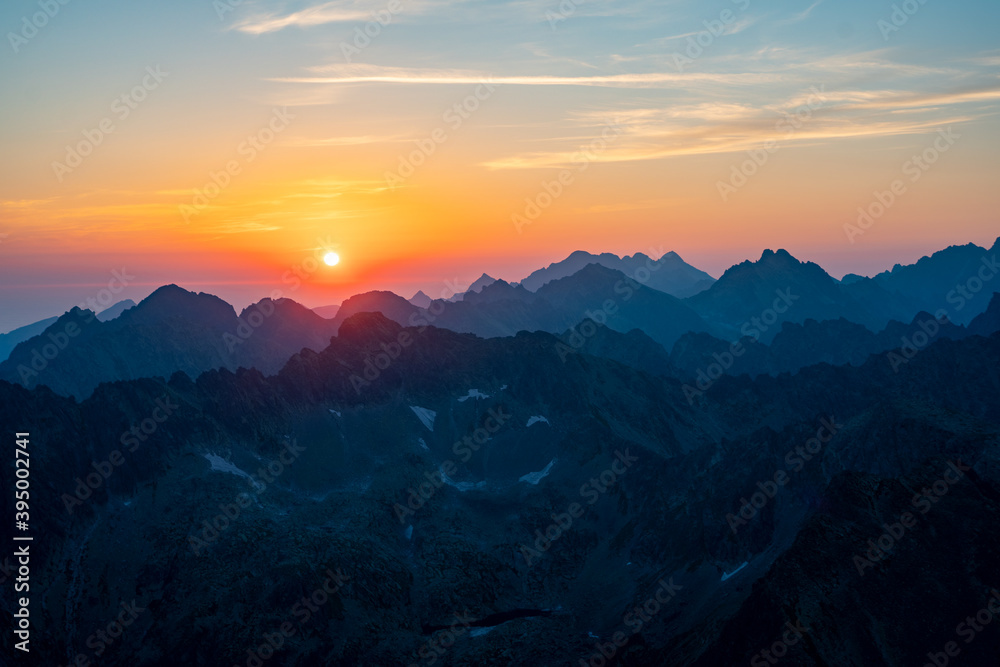Naklejka premium Panorama of early sunrise in the mountains. Summer clear sky with rising sun in the high Tatras in Slovakia. Nice scenery on top in Liptov region.