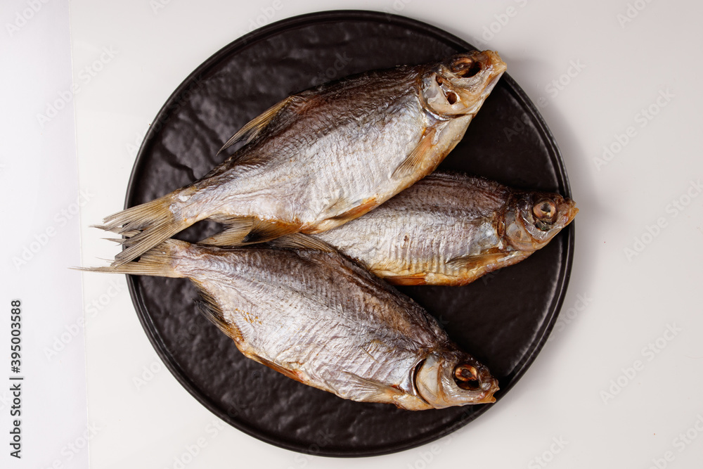 dried silver bream fish, snacks for beer on plate isolated on white dried silver bream fish, snacks for beer on plate isolated on white