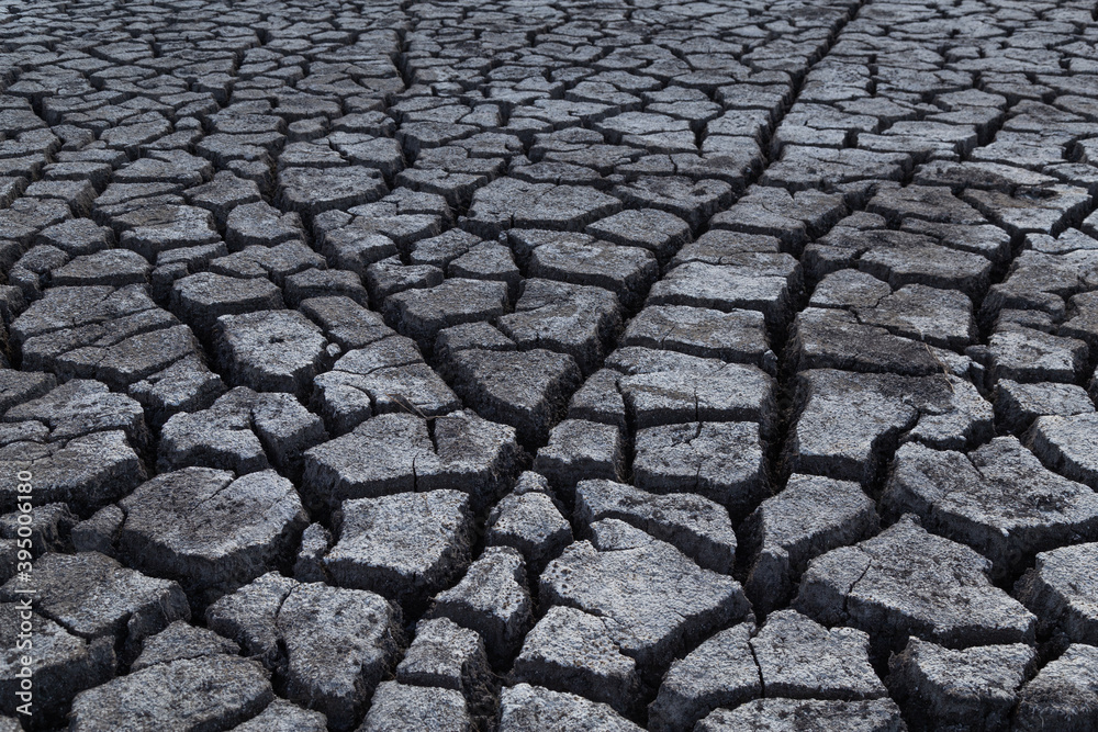 Beautiful deep cracks in the ground, dark background texture. Selective focus at wide cracks in dry soil. Effects of heat and drought.Concept of global warming, greenhouse effect. Earth climate change Beautiful deep cracks in the ground, dark background texture. Selective focus at wide cracks in dry soil. Effects of heat and drought.Concept of global warming, greenhouse effect. Earth climate change