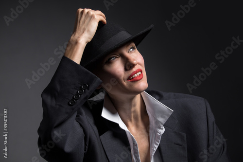 Portrait of a beautiful woman in a hat and boyfriend oversize huge suit. retro woman