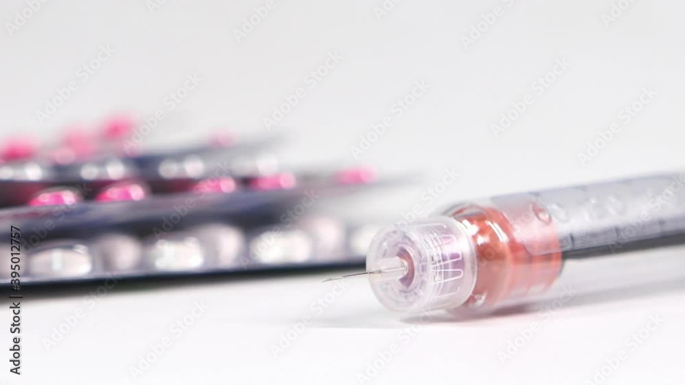 Insulin pen and pills on white background with copy space Insulin pen and pills on white background with copy space
