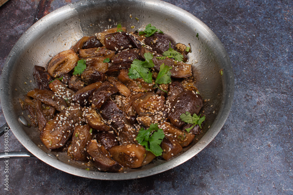 Vegan Korean eggplant gaji namul in stainless steel pan on gray background, copy space Vegan Korean eggplant gaji namul in stainless steel pan on gray background, copy space