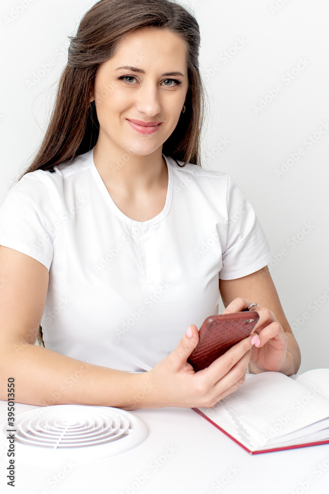 Portrait of young smiling cosmetologist with smatphone in beauty salon Portrait of young smiling cosmetologist with smatphone in beauty salon