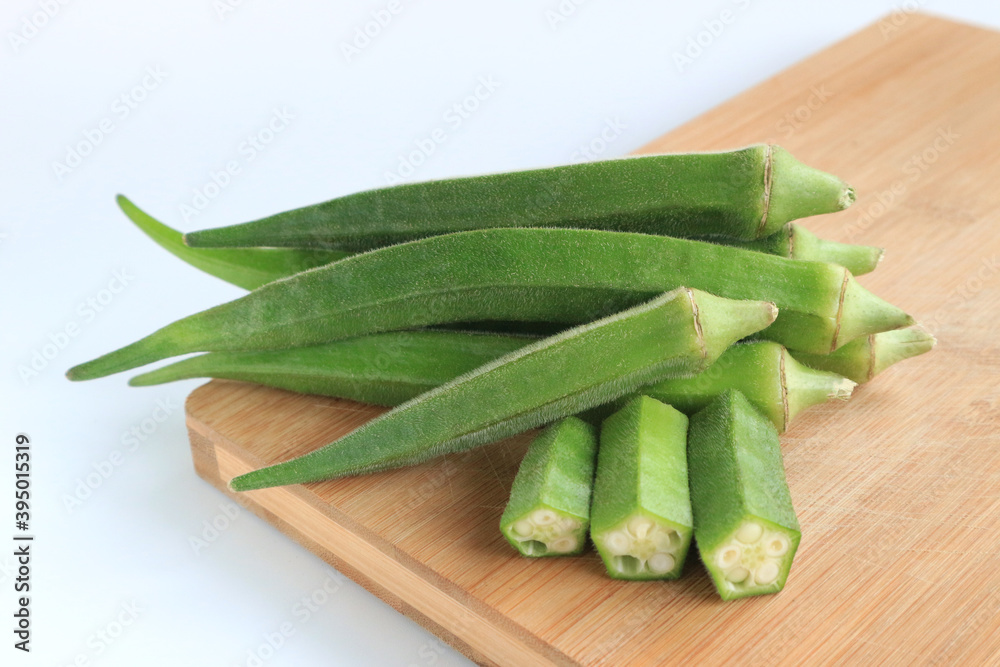 Fresh vegetable okra on wooden tray on white background Fresh vegetable okra on wooden tray on white background