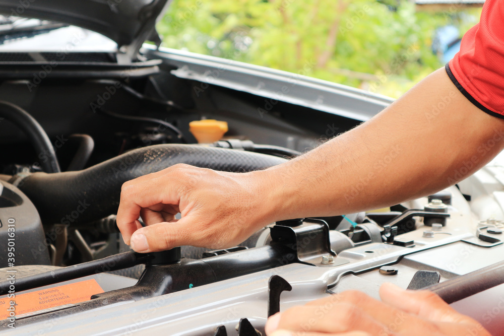 A man checking car engine at home, worker. A man checking car engine at home, worker.
