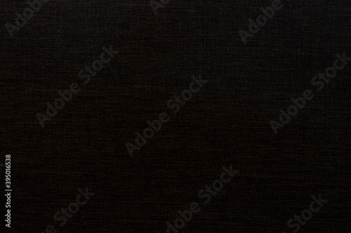 Dark brown fine patterned fabric background.