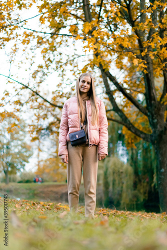 Attractive young woman enjoying her time outside in park with sunset in background. Beautiful young blond woman enjoying. Autumn Portrait of beautiful young woman. © Владислав Легір
