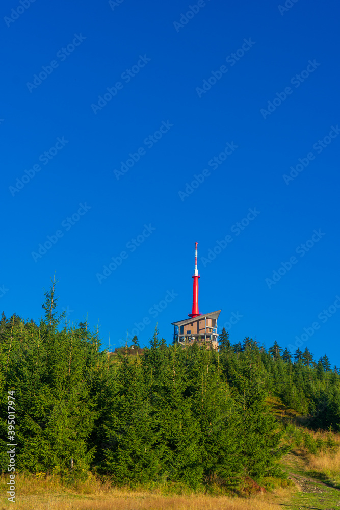 Obraz premium Lysa hora, Beskids mountains ( Beskydy ), Czech republic / Czechia, Central Europe - pathway leading to top of the hill. High building of Transmission tower on the peak. Late Summer with dry grass