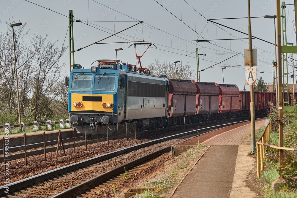 Freight train on the rails passing through a station Freight train on the rails passing through a station