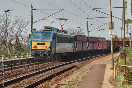 Freight train on the rails passing through a station