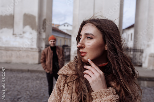 Young fashion couple posing on the old street in fall. Pretty beautiful woman and her handsome stylish boyfriend on the street on autumn day