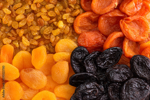 Raisins, prunes, dried fruits as a background.