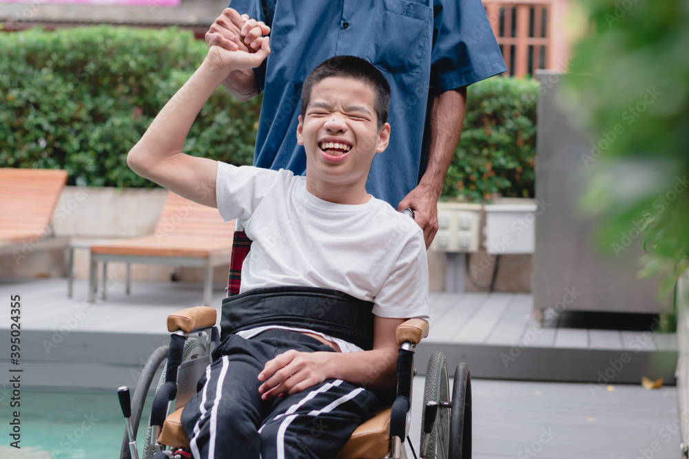 Obraz premium Asian special child on wheelchair and parent with swimming pool background,The boy happiness in holidays with family time on the travel,Lifestyle of happy disabled kid sport travel concept.
