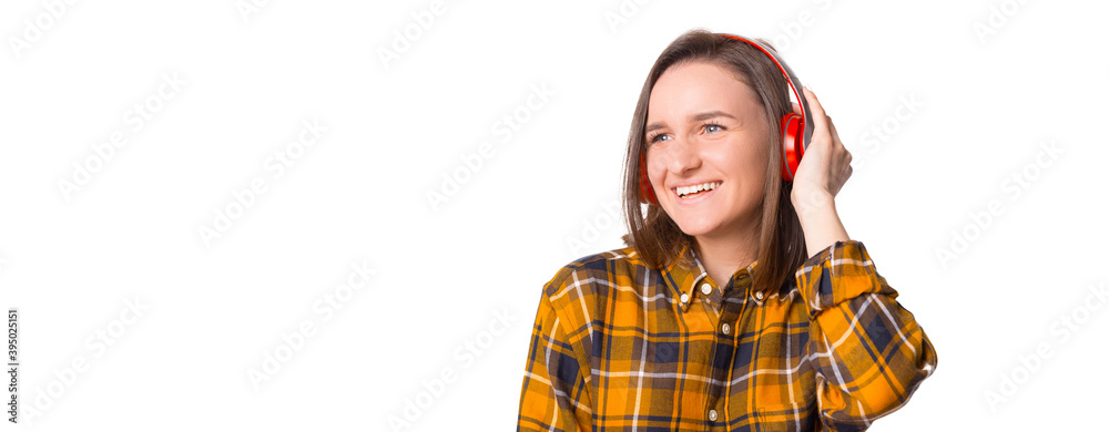 Young woman in checkered shirt enjoying music with her new headphones Young woman in checkered shirt enjoying music with her new headphones