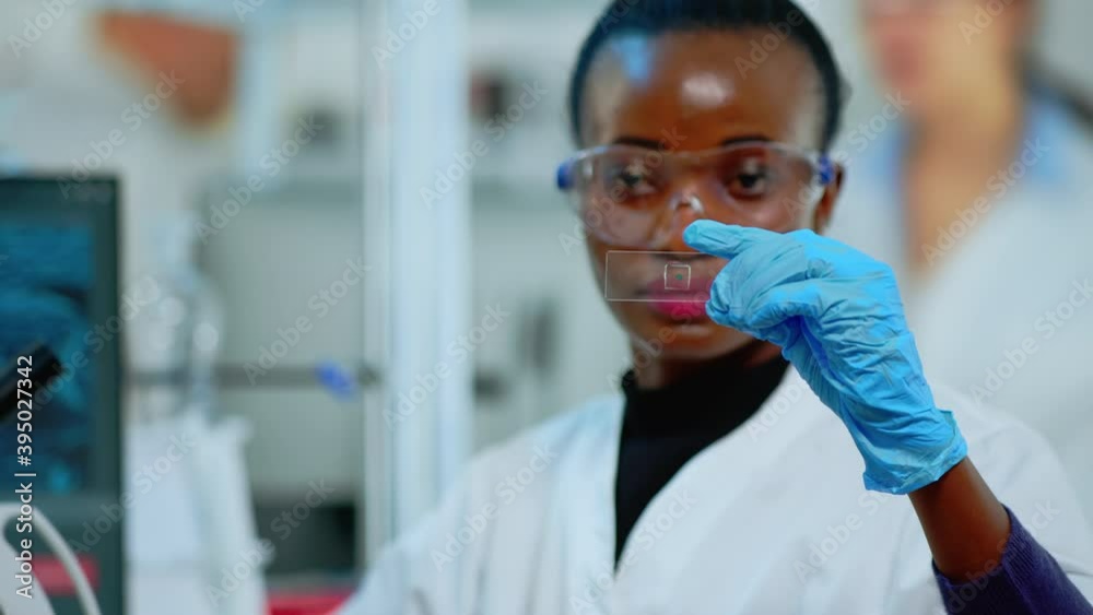 Black technician doing experiment in modern equipped lab looking at result. African scientist working with various bacteria tissue and blood samples, concept of pharmaceutical research for antibiotics Black technician doing experiment in modern equipped lab looking at result. African scientist working with various bacteria tissue and blood samples, concept of pharmaceutical research for antibiotics