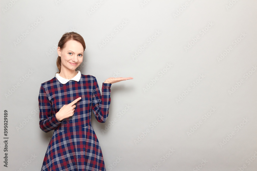 Happy girl is pointing with index finger at copy space on open palm Happy girl is pointing with index finger at copy space on open palm