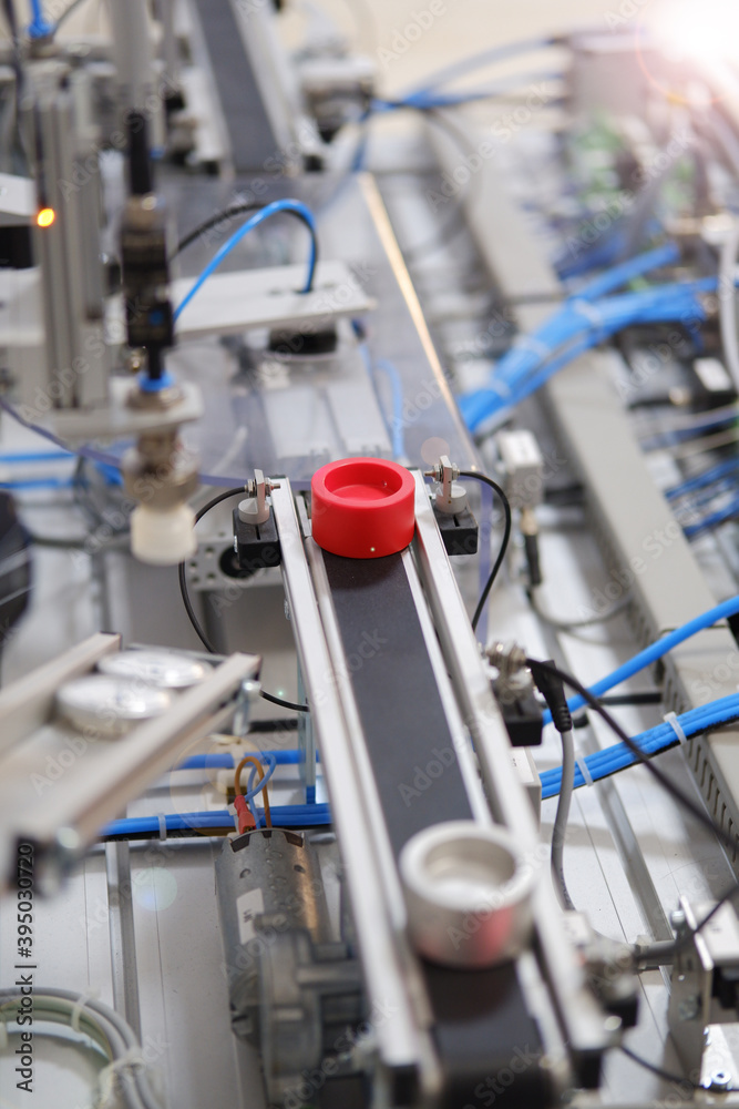 Industry 4.0 concept; artificial intelligence in smart factory. Close-up of product which is classified by sensors on assembly line equipped with sensors and pneumatic pieces of equipment. Industry 4.0 concept; artificial intelligence in smart factory. Close-up of product which is classified by sensors on assembly line equipped with sensors and pneumatic pieces of equipment.