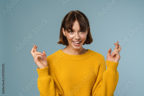 Happy woman in sweater praying with crossed arms
