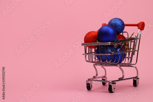 Christmas tree toys, balls in a shopping trolley. Концепция shopping, delivery of goods, copy space for text
