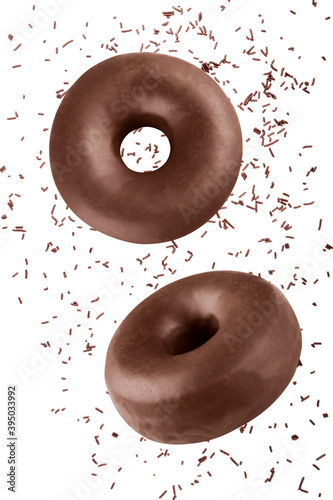 Vertical composition of donuts flying covered with chocolate frosting with chocolate sprinkles isolated on a white background. Funny and delicious dark chocolate doughnuts