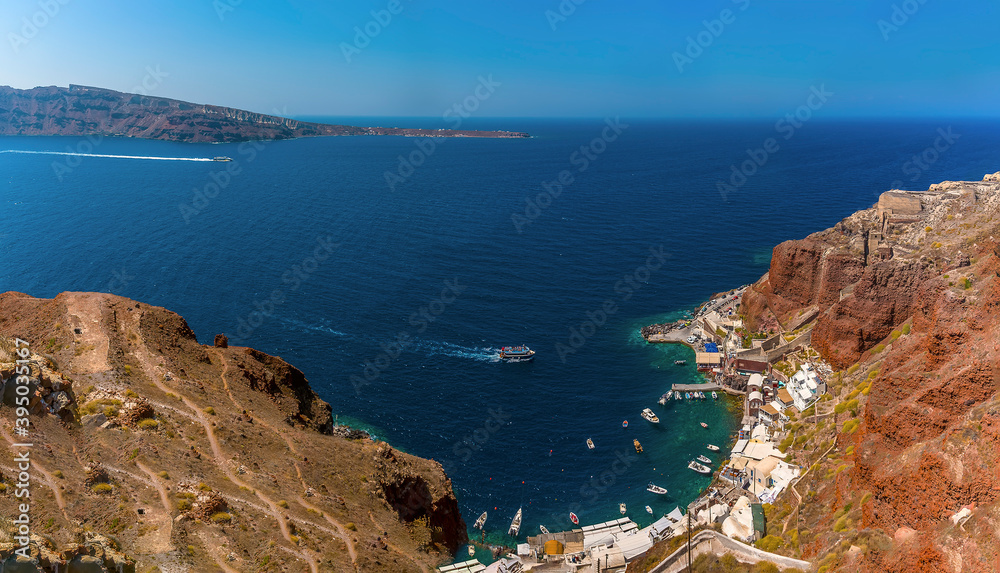 Amoudi Bay nestled beneath the red cliffs of the village of Oia, Santorini in summertime