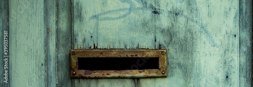 old mailbox slot on wooden turquoise door, close up shot. photo