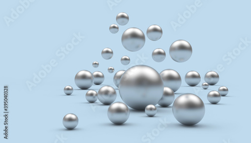 A group of falling silver spheres of various sizes on a light blue background. 3d illustration