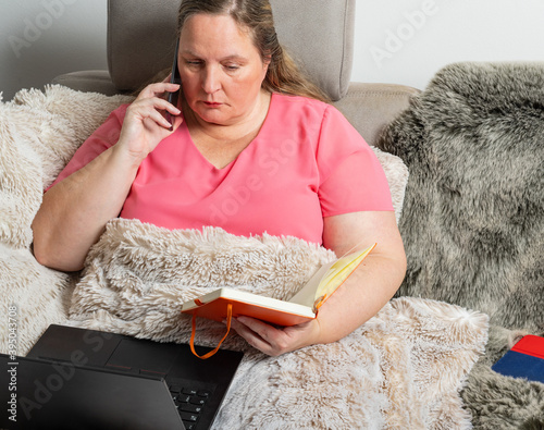 Frau arbeitet auf ein Sofa mit einem Notebook, Tablet PC und Handy im Homeoffice  