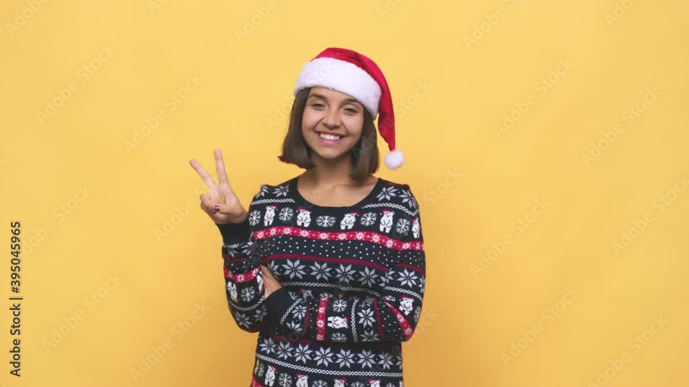 Young latin woman celebrating christmas day showing number two with fingers Young latin woman celebrating christmas day showing number two with fingers