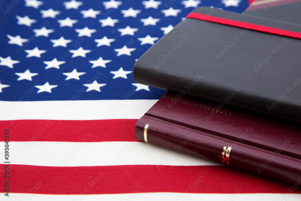 Journal and ledger books placed on American flag reflects concepts of nationalism, business, and accountability