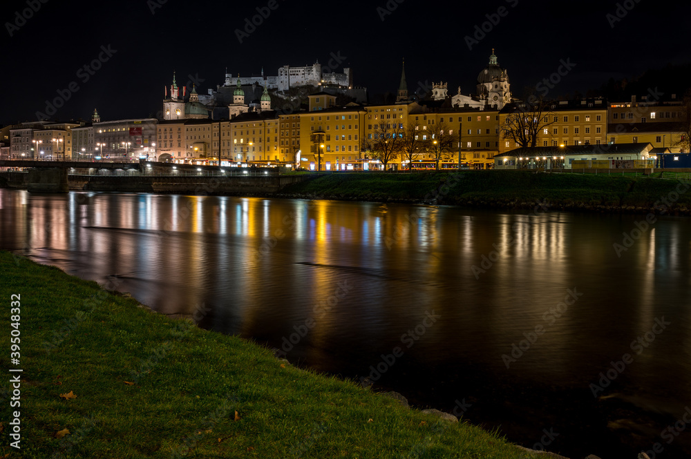 city of salzburg with castle at night at river salzach