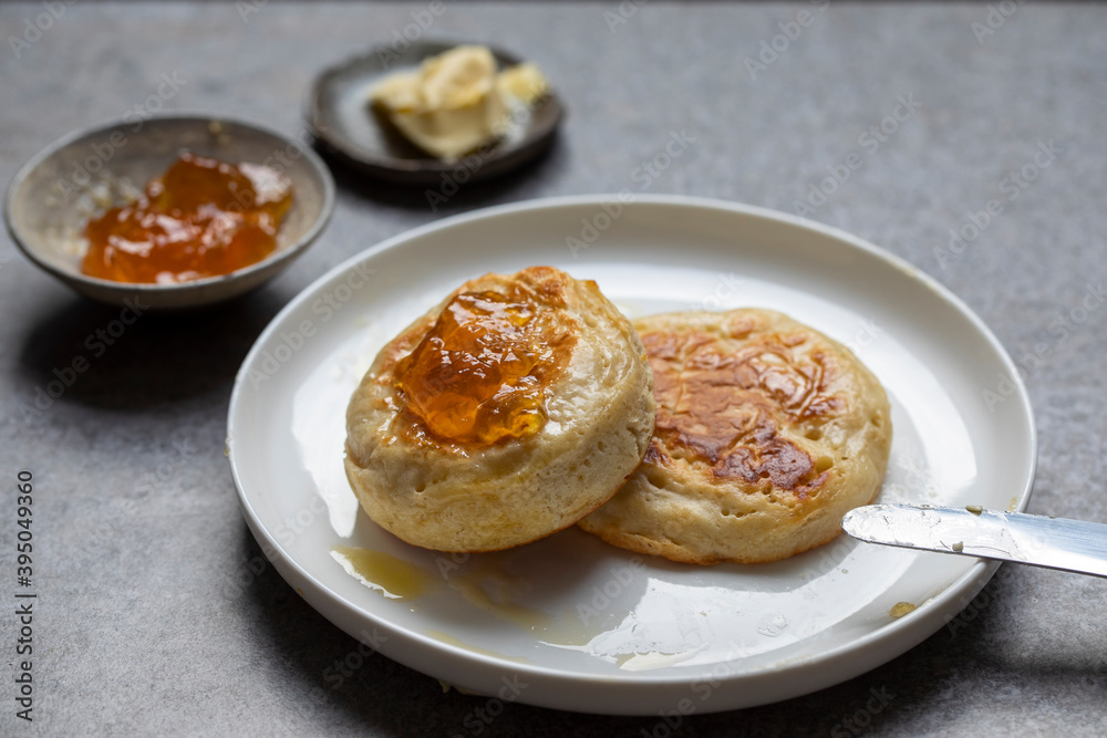 Home made crumpets with butter and orange jam Home made crumpets with butter and orange jam