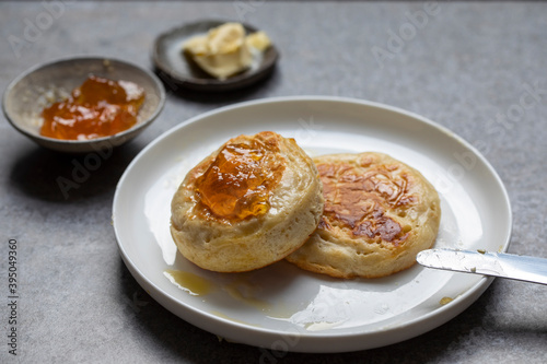 Home made crumpets with butter and orange jam