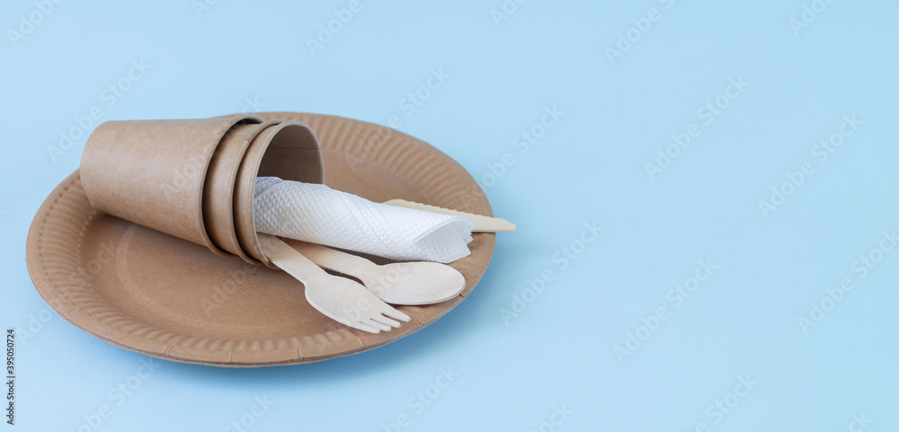 Fototapeta premium Disposable eco friendly utensils made of bamboo wood and paper on blue background