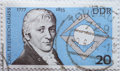 a postage stamp from Germany, GDR showing a portrait of Carl Friedrich Gauß (1777–1855), mathematician, astronomer and physicist, as well as a seventeenth corner with compass and isosceles triangle. photo