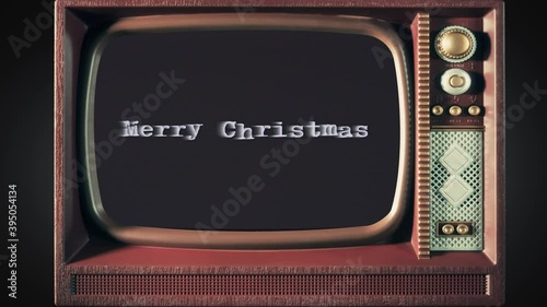 Inside a toy tv: a scary text, Merry Christmas, appearing on the screen, with a light behind the typewriter font, typical of a horror flick (b-movie).
