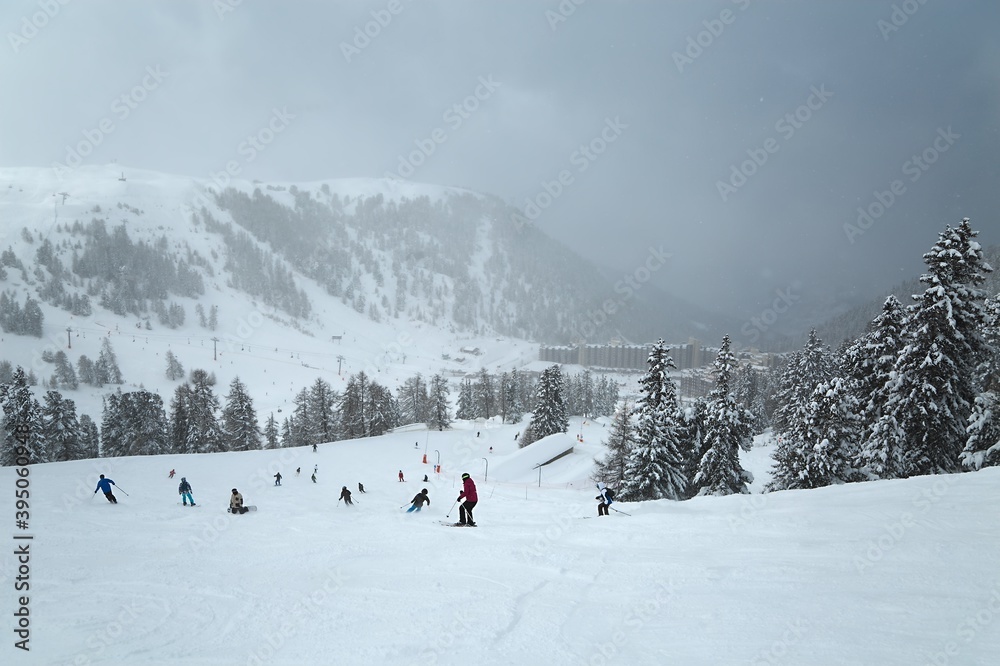 Skiing slope in the French Alpes, cloudy weather, falling snow