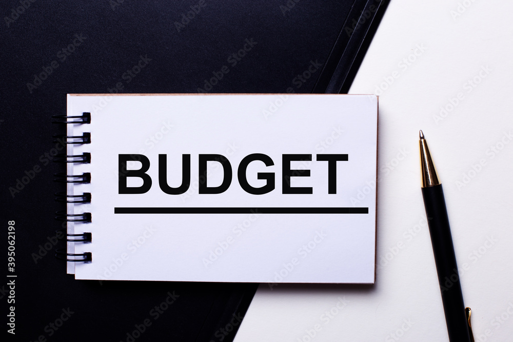 BUDGET written in red on a black and white background near the pen BUDGET written in red on a black and white background near the pen