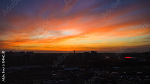 City is on a sky background with orange and yellow sunset or sunrise