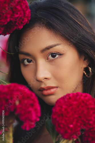 Obraz na płótnie closeup portrait of a beautiful young Thai woman surrounded by red flowers. Spring blossom w salonie
